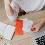 Budget Planning - Woman Sitting Behind the Desk and Looking at Receipts 