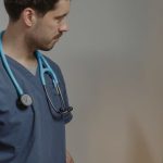 Veterinarian Clinic - Man in Blue Scrub Suit Standing in Front of an Ultrasound Machine