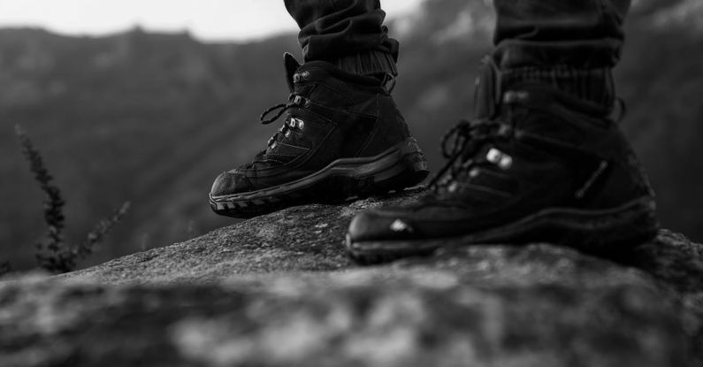 Hiking Boots - Monochrome Photo of Person Wearing Black Shoes