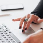 Startup Office - Crop female using touchpad on laptop in office