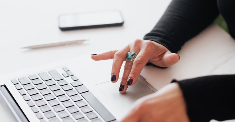 Startup Office - Crop female using touchpad on laptop in office