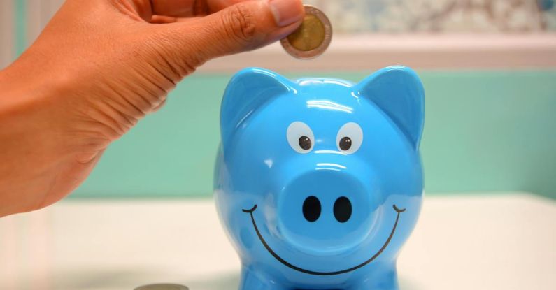 Saving Money - Person Putting Coin in a Piggy Bank