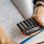 Tax Documents - Person Holding Black Calculator While Using Laptop