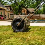 Backyard Landscaping - A Person Cutting Grass on the Backyard