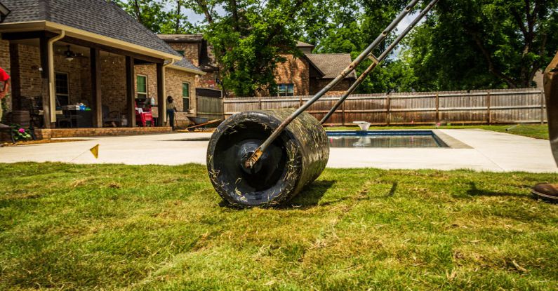 Backyard Landscaping - A Person Cutting Grass on the Backyard