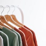 Organized Closet - Light room interior with collection of various garments on wooden racks in wardrobe near white walls