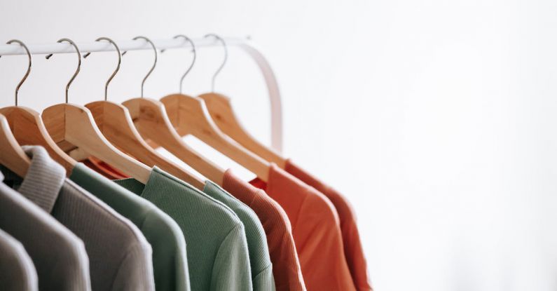 Organized Closet - Light room interior with collection of various garments on wooden racks in wardrobe near white walls