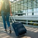Travel Suitcase - Woman Walking on Pathway While Strolling Luggage