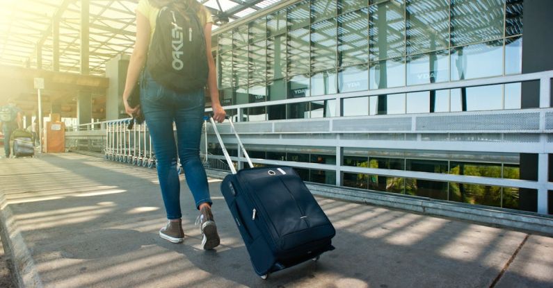 Travel Suitcase - Woman Walking on Pathway While Strolling Luggage