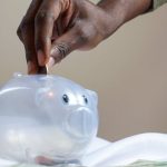 Piggy Bank - Person Putting Coin in a Piggy Bank